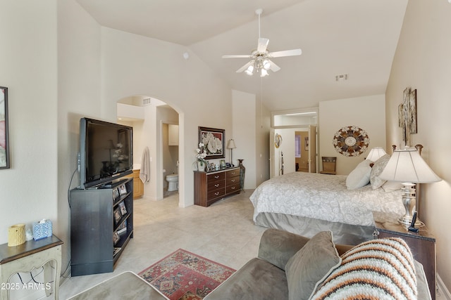 bedroom featuring ceiling fan, lofted ceiling, and ensuite bath