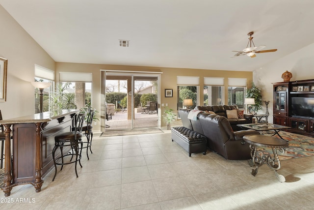 living room featuring ceiling fan, light tile patterned floors, and lofted ceiling