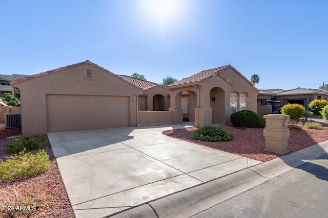 mediterranean / spanish-style home featuring a garage and central air condition unit