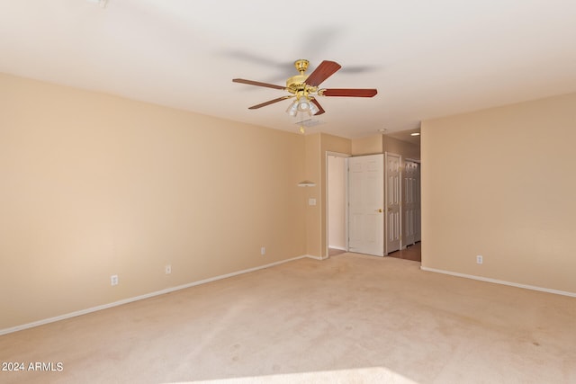 carpeted spare room with ceiling fan