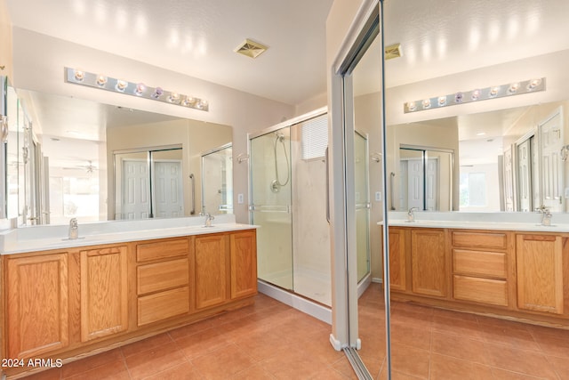 bathroom featuring vanity, tile patterned flooring, and walk in shower