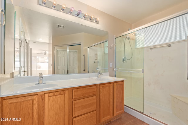 bathroom with vanity, a shower with shower door, tile patterned floors, and ceiling fan