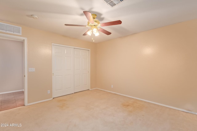 unfurnished bedroom with a closet, carpet, and ceiling fan