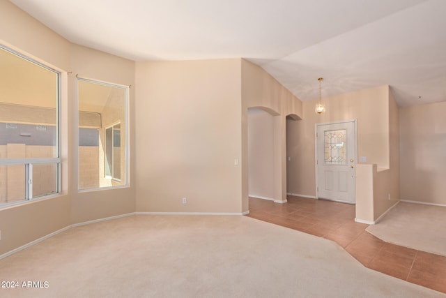 carpeted empty room featuring lofted ceiling