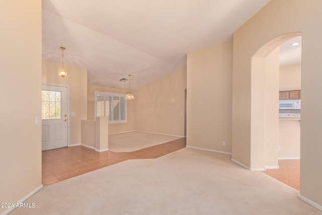 carpeted spare room featuring lofted ceiling