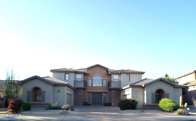 view of front facade featuring a garage and a balcony