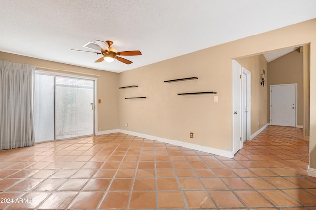 tiled empty room featuring ceiling fan and a textured ceiling