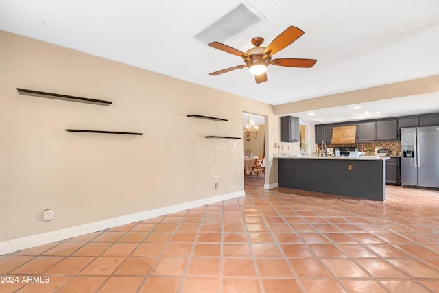 unfurnished living room with ceiling fan and light tile patterned floors