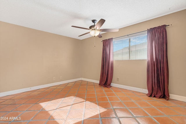 spare room with ceiling fan, light tile patterned flooring, and a textured ceiling