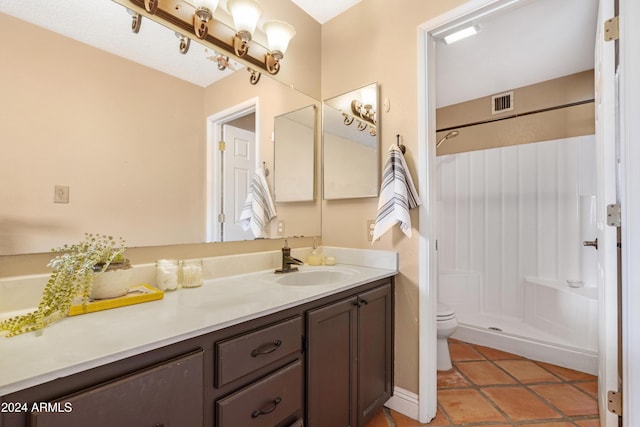 bathroom with tile patterned flooring, toilet, vanity, and walk in shower