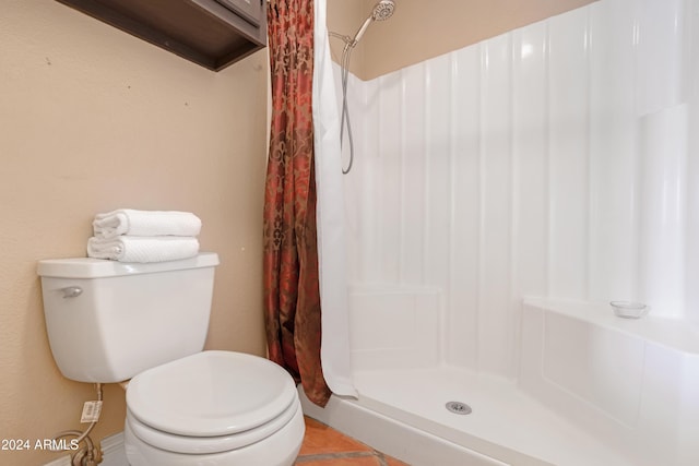 bathroom with tile patterned floors, toilet, and walk in shower