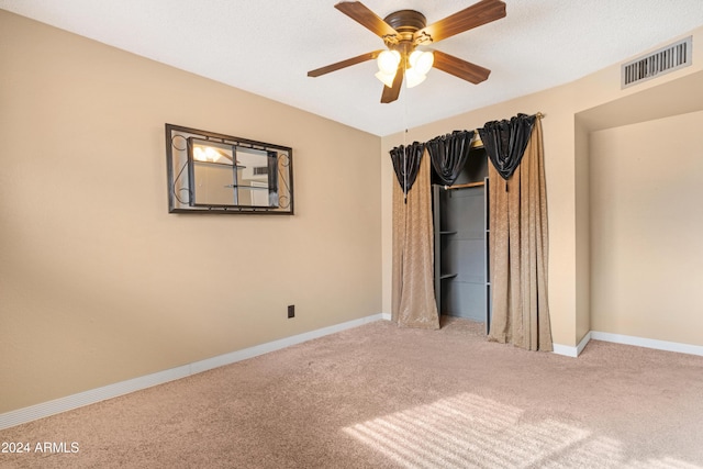 unfurnished bedroom with ceiling fan and light colored carpet