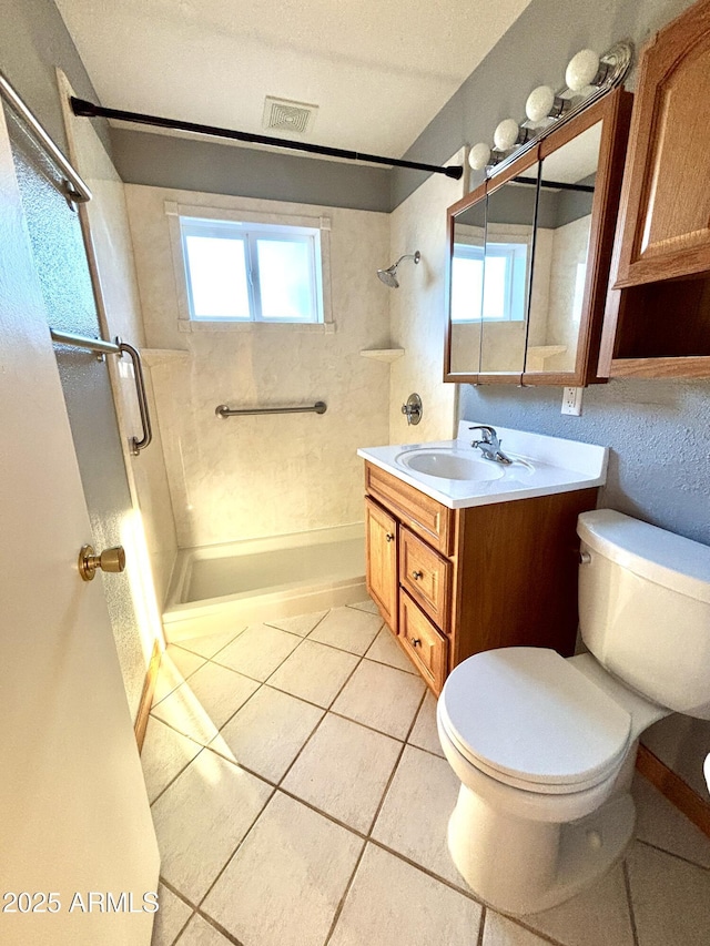 bathroom with tiled shower, tile patterned floors, toilet, a textured ceiling, and vanity