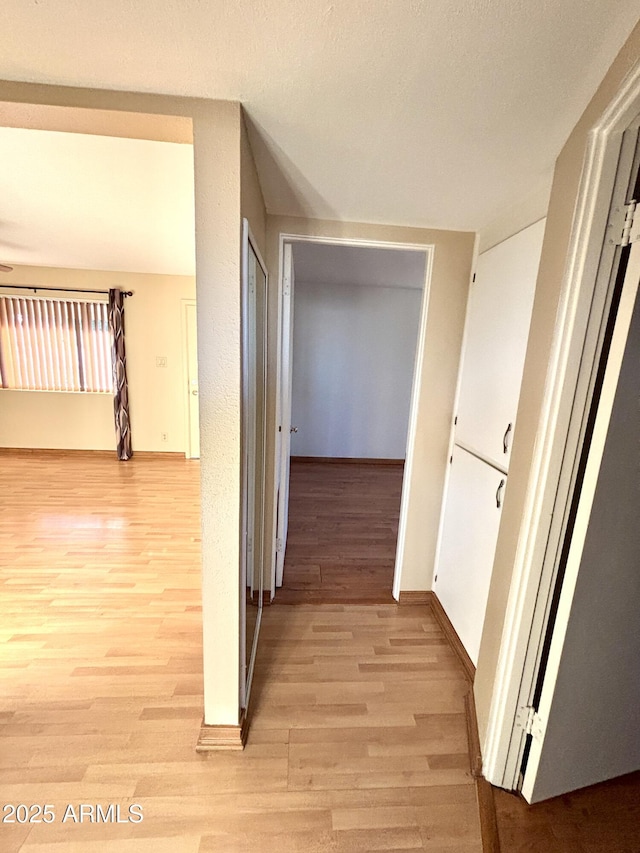 corridor with light wood-type flooring