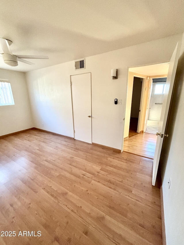 empty room with light hardwood / wood-style flooring and ceiling fan