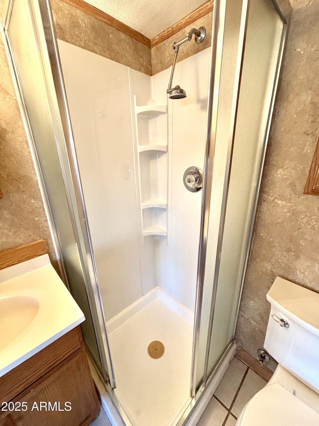 bathroom with tile patterned floors, toilet, a shower with shower door, a textured ceiling, and vanity