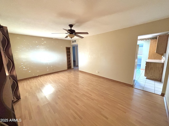 empty room featuring ceiling fan and light hardwood / wood-style flooring