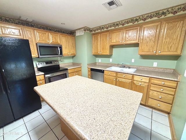 kitchen featuring stainless steel appliances, sink, and light tile patterned floors