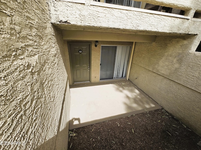 view of exterior entry featuring stucco siding