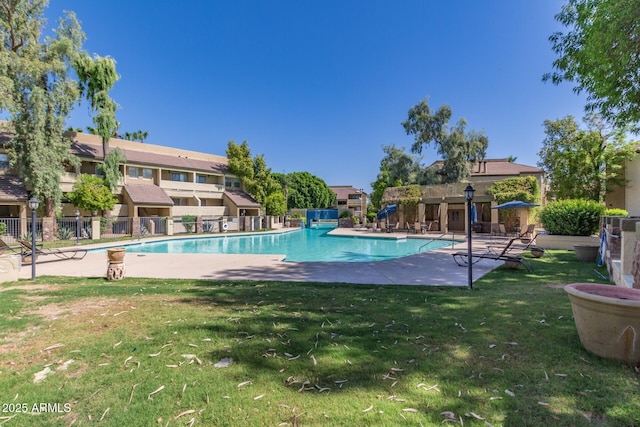 pool featuring a patio area, a lawn, and fence