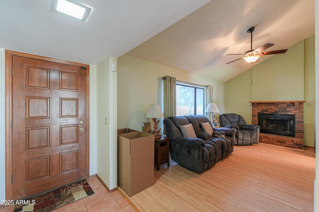 18622 E Via De Arboles, Queen Creek, AZ 85142 - living room with a ceiling fan, a textured ceiling, a fireplace, light wood finished floors, and vaulted ceiling