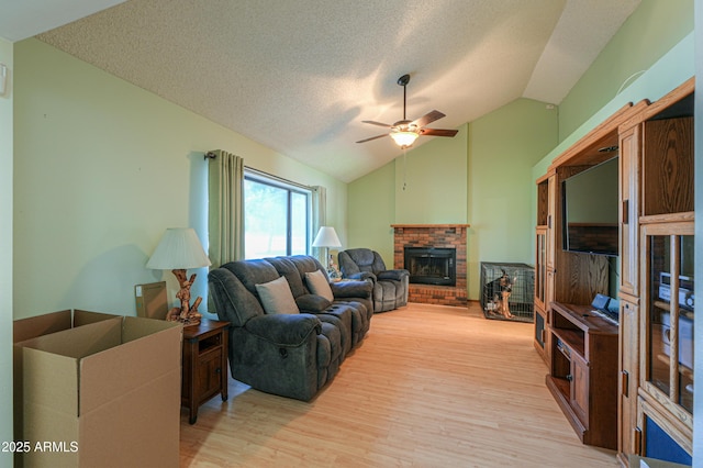 18622 E Via De Arboles, Queen Creek, AZ 85142 - living room featuring light wood-style flooring, a textured ceiling, a fireplace, ceiling fan, and vaulted ceiling