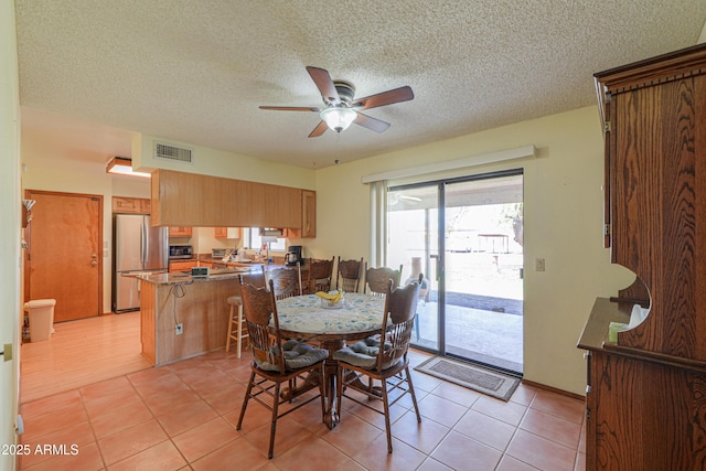 18622 E Via De Arboles, Queen Creek, AZ 85142 - dining room featuring light tile patterned floors, visible vents, a textured ceiling, and ceiling fan