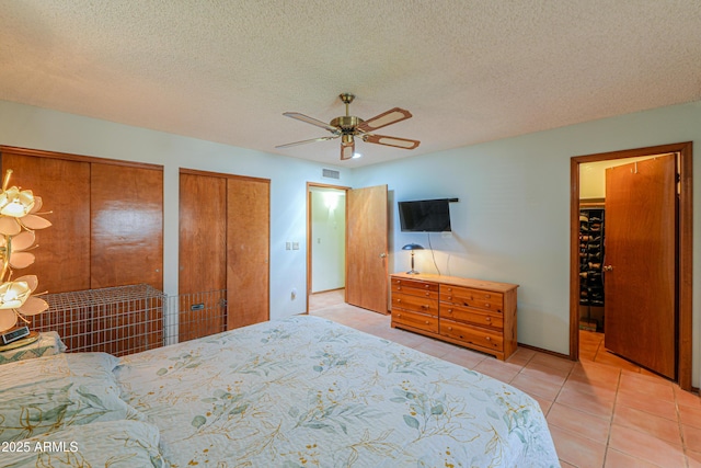 18622 E Via De Arboles, Queen Creek, AZ 85142 - bedroom with visible vents, two closets, a ceiling fan, a textured ceiling, and light tile patterned flooring