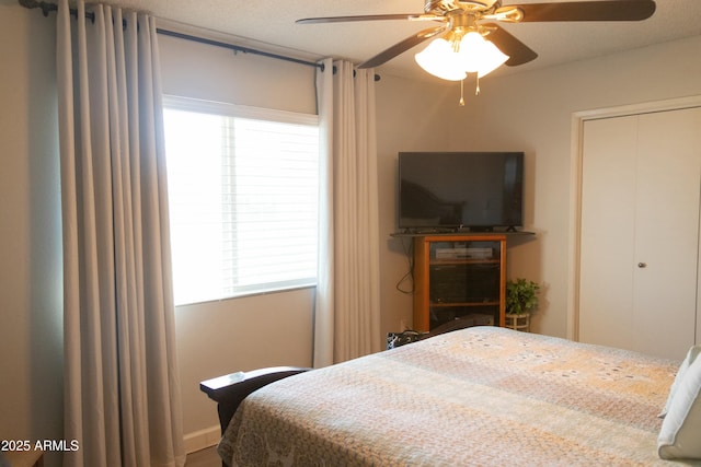bedroom featuring a closet, multiple windows, a textured ceiling, and ceiling fan