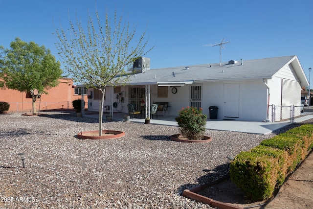 back of house featuring a gate, fence, and a patio area