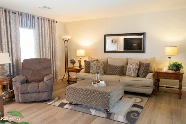 living room featuring visible vents and wood finished floors