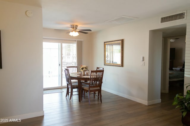 dining area with dark wood finished floors, visible vents, baseboards, and a ceiling fan