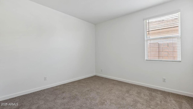 empty room featuring carpet flooring and baseboards