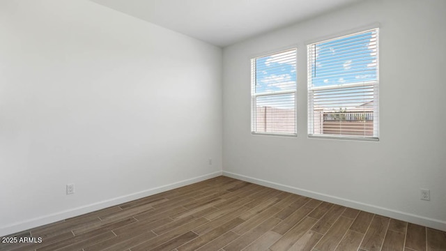 unfurnished room with baseboards and wood finished floors