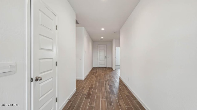 hallway with baseboards, recessed lighting, and dark wood-type flooring