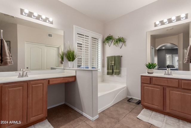 bathroom featuring tile patterned floors, a tub, and vanity