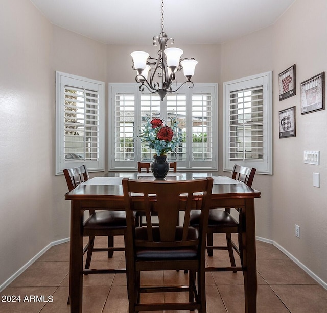 dining space featuring tile patterned floors and an inviting chandelier