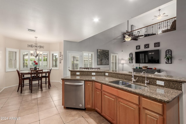 kitchen featuring dark stone countertops, hanging light fixtures, sink, and dishwasher