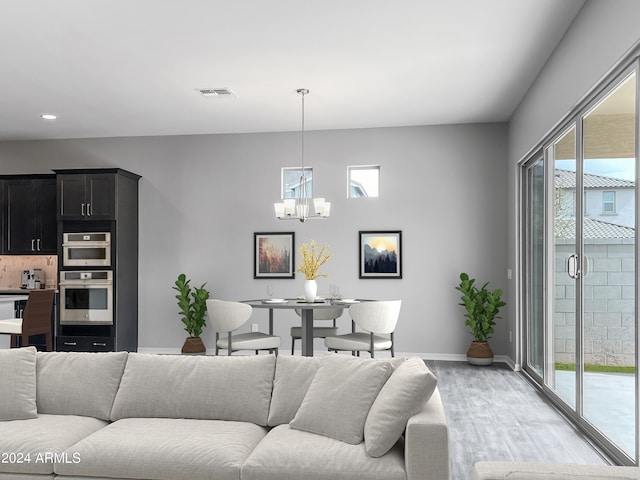 living room with a notable chandelier and light wood-type flooring