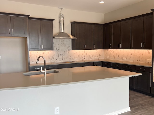 kitchen featuring a kitchen island with sink, sink, dark wood-type flooring, wall chimney exhaust hood, and black electric stovetop