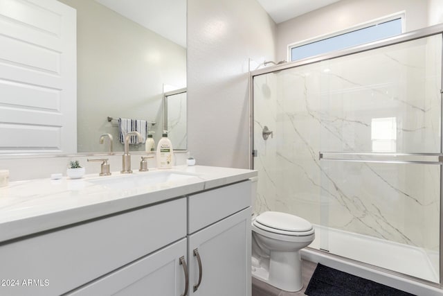 bathroom featuring vanity, toilet, and an enclosed shower