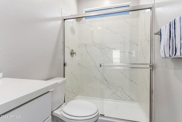 bathroom featuring vanity, an enclosed shower, and toilet