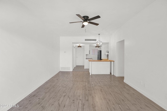 6125 E Indian School Rd Unit 240, Scottsdale, AZ 85251 - unfurnished living room featuring wood finished floors, a ceiling fan, and baseboards