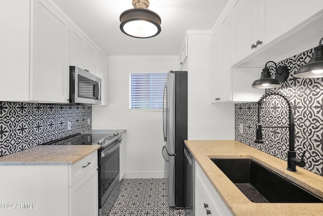 6125 E Indian School Rd Unit 240, Scottsdale, AZ 85251 - kitchen featuring appliances with stainless steel finishes, a sink, decorative backsplash, and white cabinets