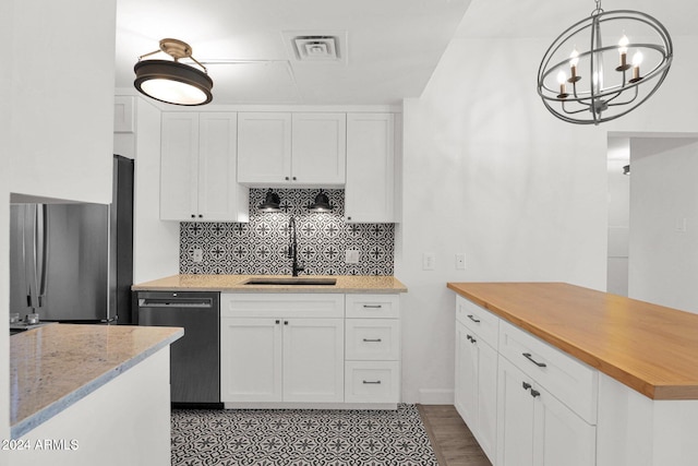 6125 E Indian School Rd Unit 240, Scottsdale, AZ 85251 - kitchen featuring dishwashing machine, a sink, freestanding refrigerator, backsplash, and white cabinetry