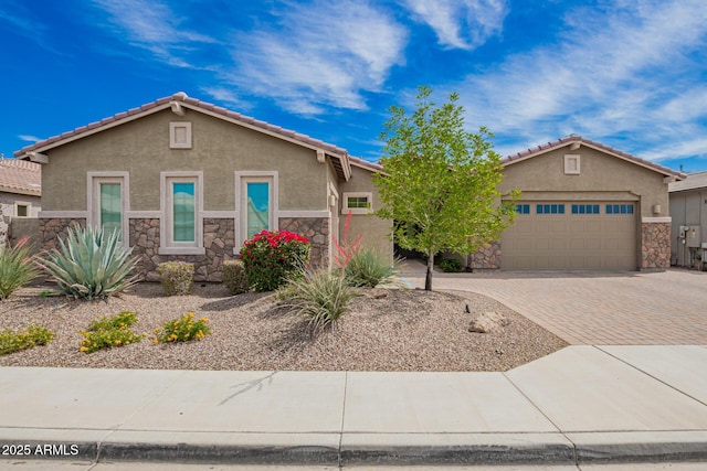 view of front facade featuring stone siding, stucco siding, decorative driveway, an attached garage, and a tiled roof