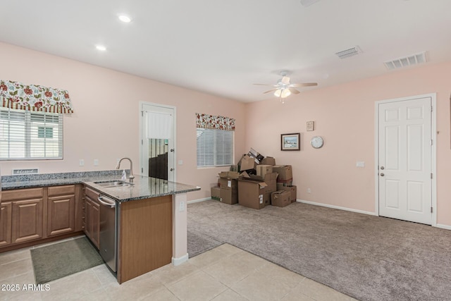 kitchen featuring a sink, light colored carpet, open floor plan, stainless steel dishwasher, and ceiling fan