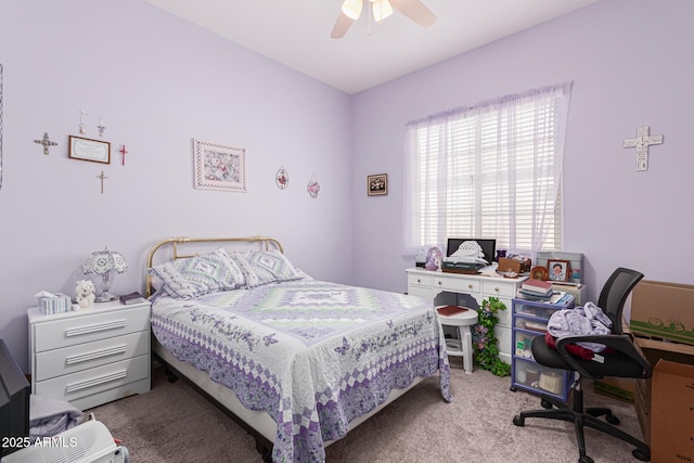 carpeted bedroom featuring ceiling fan and a desk