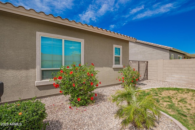 view of home's exterior with fence and stucco siding