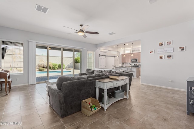 living area with a ceiling fan and baseboards